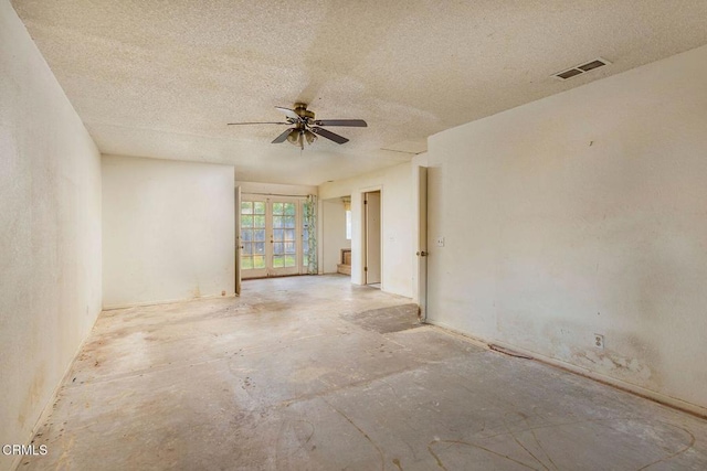 empty room with a ceiling fan, visible vents, a textured ceiling, and french doors