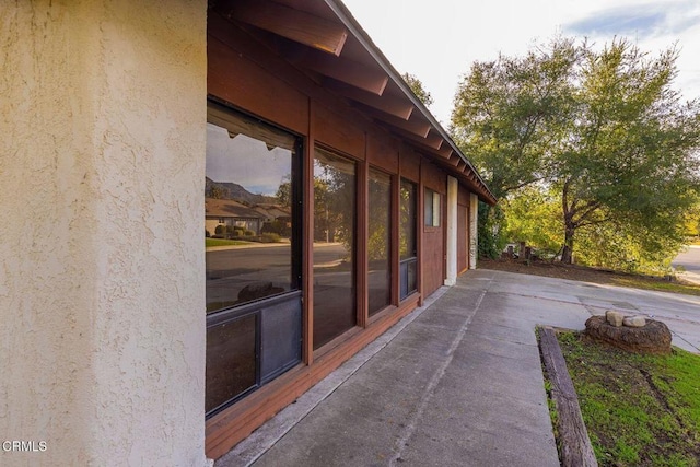 view of side of home with a patio area and stucco siding