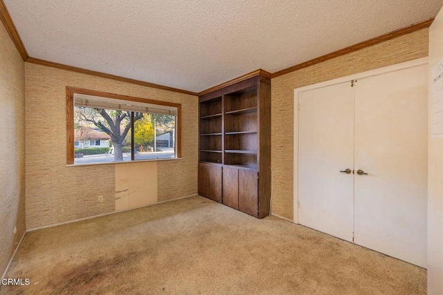 unfurnished bedroom featuring a textured ceiling, a closet, carpet, and crown molding