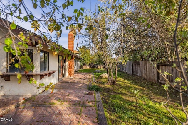 view of yard with a fenced backyard and a patio