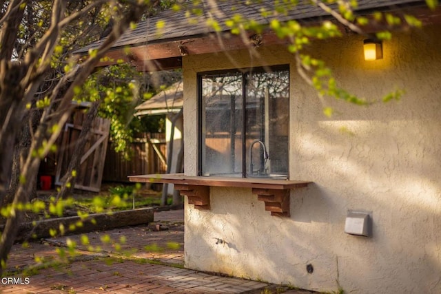 view of property exterior with a patio area and fence