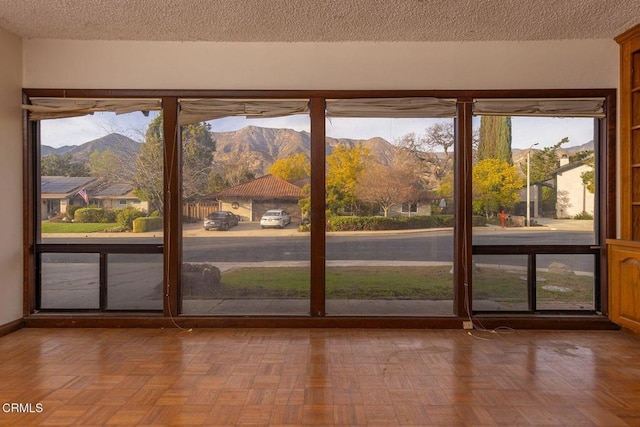 doorway to outside with a mountain view and a textured ceiling