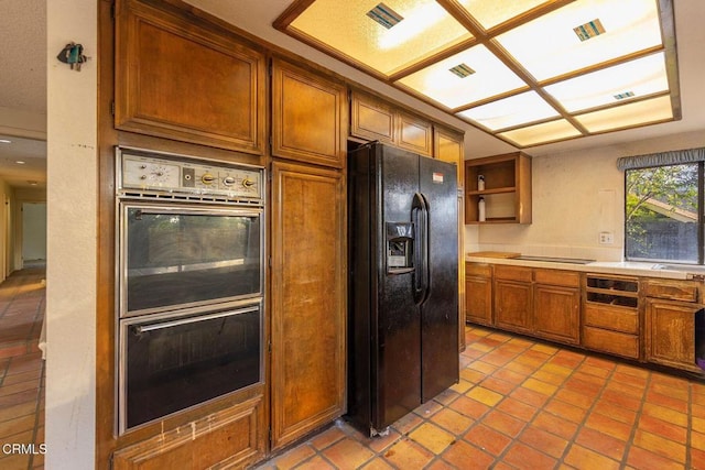 kitchen featuring brown cabinets, open shelves, tile counters, visible vents, and black appliances