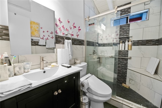 bathroom with a stall shower, tile walls, vanity, and toilet