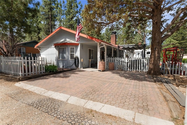 view of front of property featuring a fenced front yard and a chimney