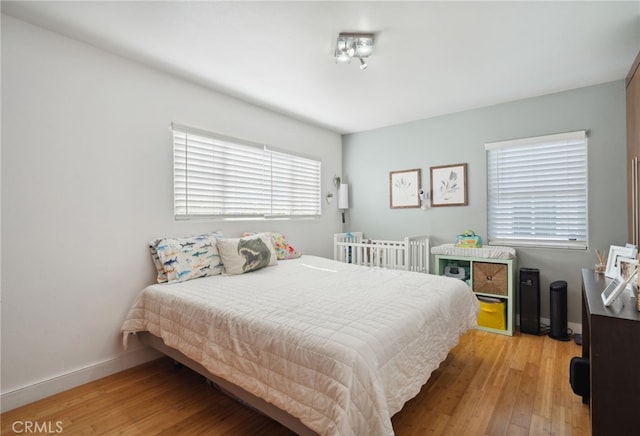 bedroom featuring light wood-style flooring and baseboards