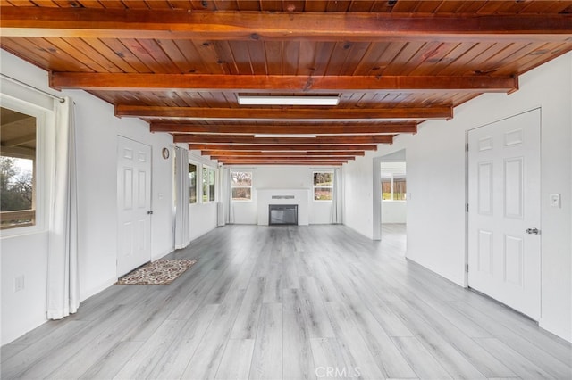 unfurnished living room featuring light wood-type flooring, beamed ceiling, a fireplace, and wooden ceiling