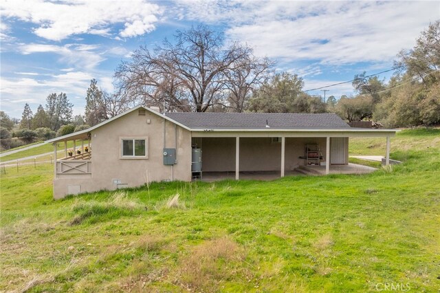 rear view of property with stucco siding and a patio