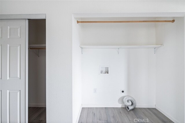 laundry area with hookup for an electric dryer, baseboards, hookup for a washing machine, wood finished floors, and laundry area