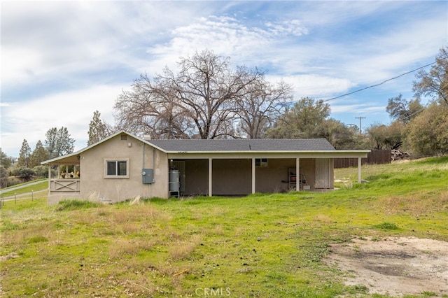 rear view of house featuring stucco siding