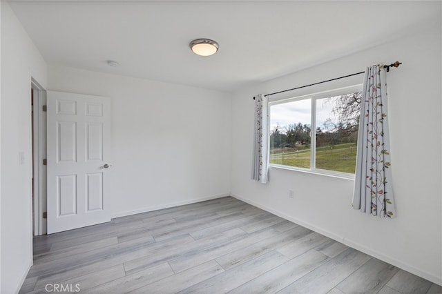 empty room with baseboards and wood finished floors