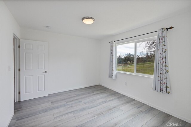 empty room featuring baseboards and wood finished floors