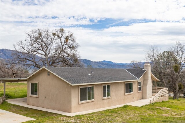 view of property exterior with stucco siding, roof with shingles, a patio area, and a chimney