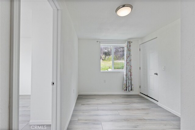 unfurnished bedroom with light wood-style flooring and baseboards