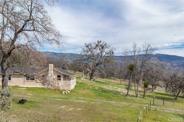 view of yard with a rural view and a mountain view
