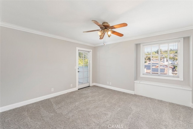 spare room featuring baseboards, carpet flooring, a ceiling fan, and crown molding