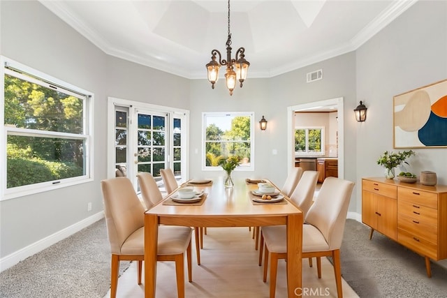 dining space featuring baseboards, visible vents, a chandelier, and crown molding