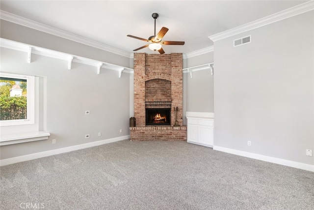 unfurnished living room with baseboards, visible vents, crown molding, carpet floors, and a brick fireplace