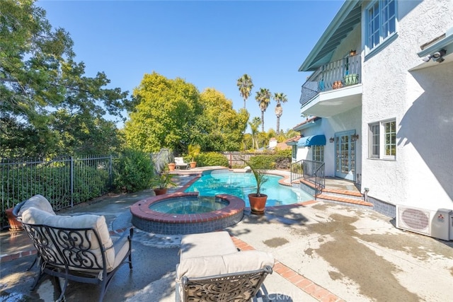 view of pool with ac unit, a fenced backyard, a pool with connected hot tub, and a patio