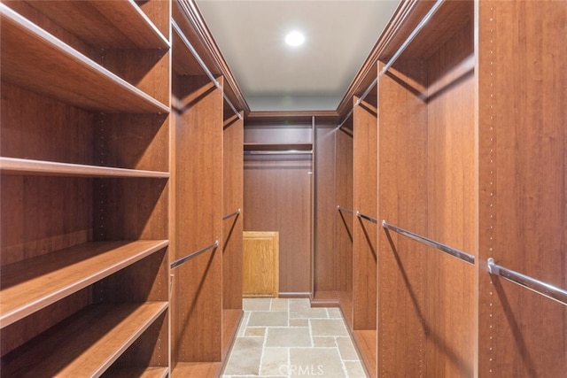 spacious closet featuring stone finish floor