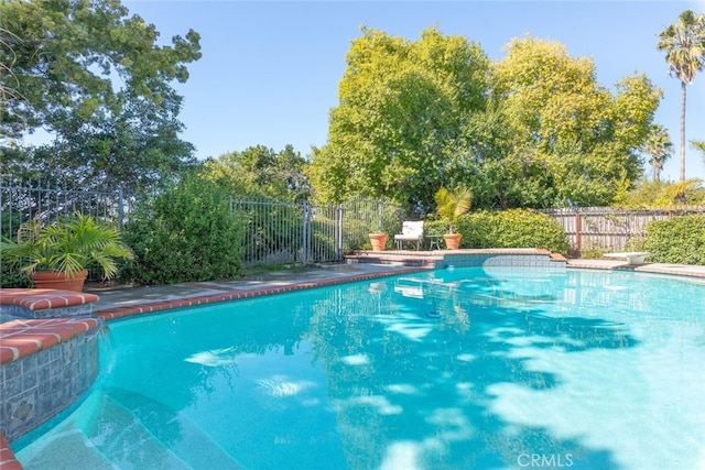 view of swimming pool featuring a diving board, fence, and a fenced in pool