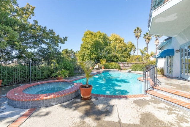 view of swimming pool with an in ground hot tub, a patio area, a fenced backyard, and a fenced in pool