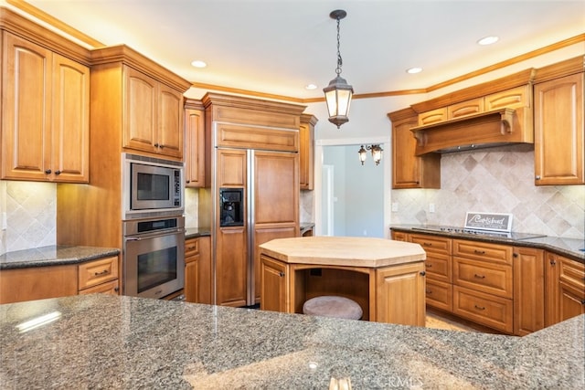 kitchen featuring decorative light fixtures, decorative backsplash, and built in appliances