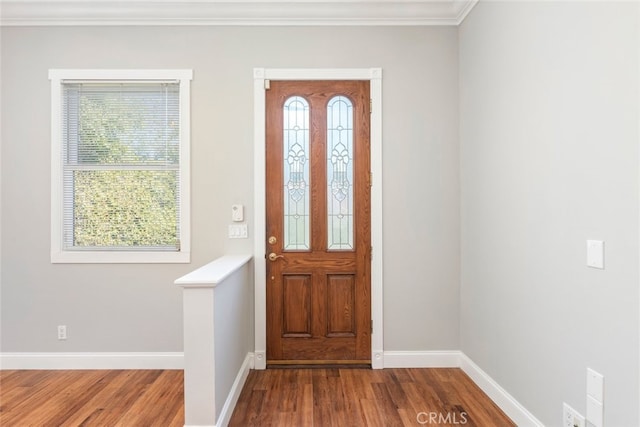 entryway with plenty of natural light, crown molding, baseboards, and wood finished floors