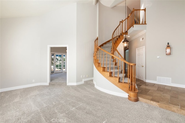 stairs featuring high vaulted ceiling, baseboards, visible vents, and carpet