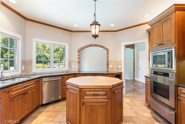 kitchen featuring a warming drawer, stone tile flooring, backsplash, appliances with stainless steel finishes, and a sink