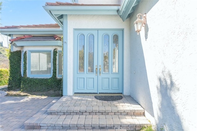 property entrance with stucco siding