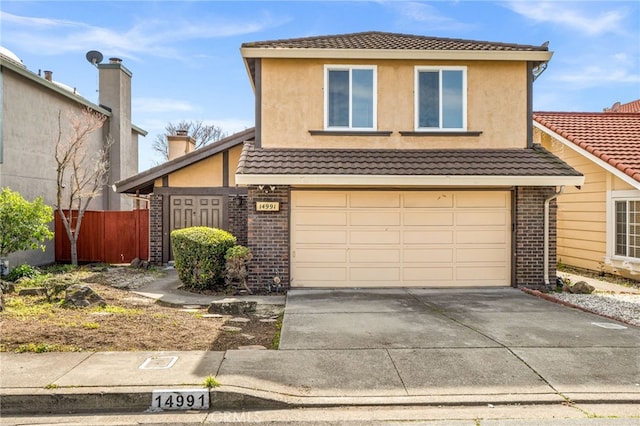 view of front of home featuring fence, driveway, an attached garage, stucco siding, and brick siding