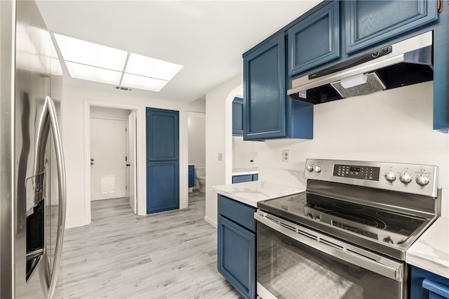 kitchen with visible vents, blue cabinetry, under cabinet range hood, light stone counters, and appliances with stainless steel finishes