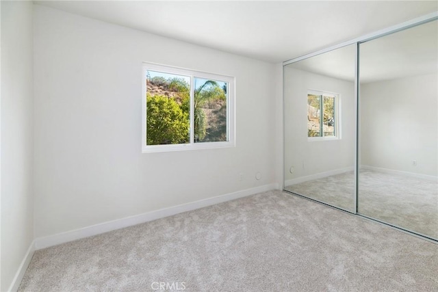 unfurnished bedroom with carpet and multiple windows