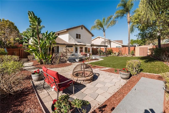 rear view of house with a yard, a fenced backyard, stucco siding, and a patio