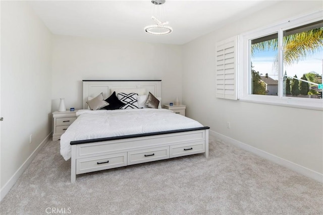 bedroom with light colored carpet and baseboards