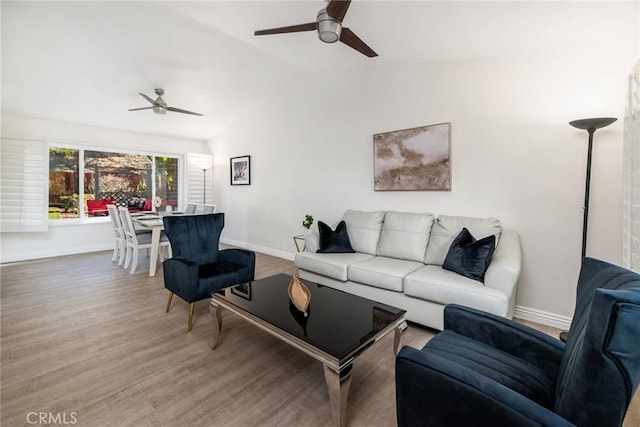 living room featuring lofted ceiling, a ceiling fan, baseboards, and wood finished floors