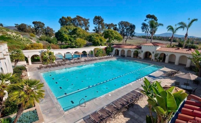 pool with a patio and a mountain view