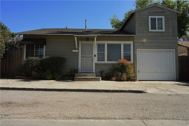 split level home with a garage, driveway, and fence