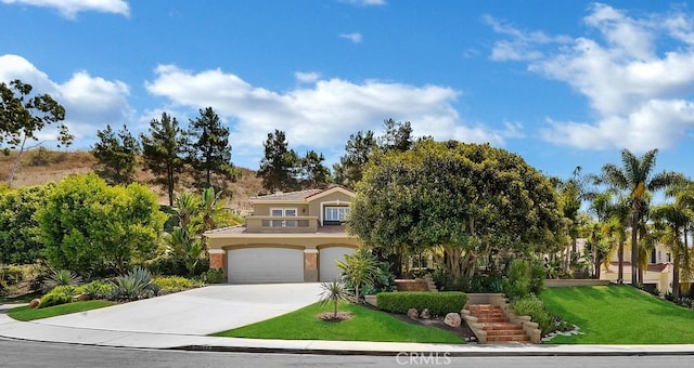 view of front of property featuring concrete driveway, a tiled roof, an attached garage, a front yard, and stucco siding