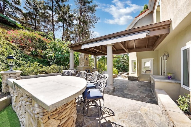 view of patio / terrace featuring exterior fireplace and outdoor dry bar