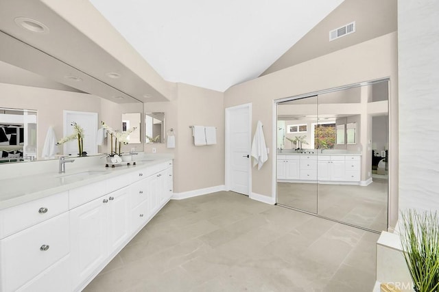 bathroom with lofted ceiling, visible vents, vanity, and baseboards