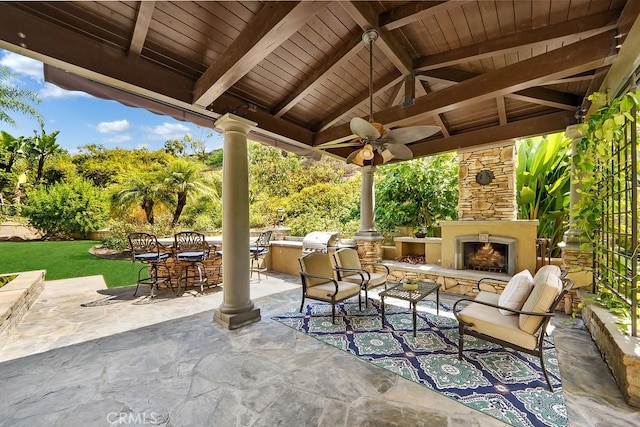 view of patio featuring an outdoor kitchen, a grill, outdoor dining area, a gazebo, and an outdoor stone fireplace