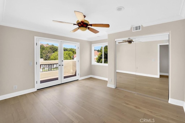 spare room featuring baseboards, visible vents, wood finished floors, and french doors