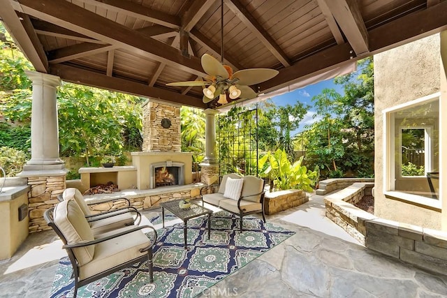 view of patio featuring ceiling fan and an outdoor stone fireplace