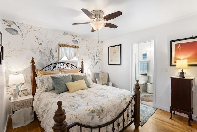 bedroom featuring connected bathroom, wood finished floors, a ceiling fan, baseboards, and wallpapered walls