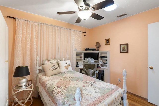 bedroom featuring ceiling fan, visible vents, and wood finished floors