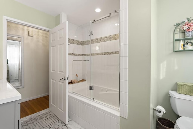 bathroom featuring tiled shower / bath combo, baseboards, toilet, and vanity