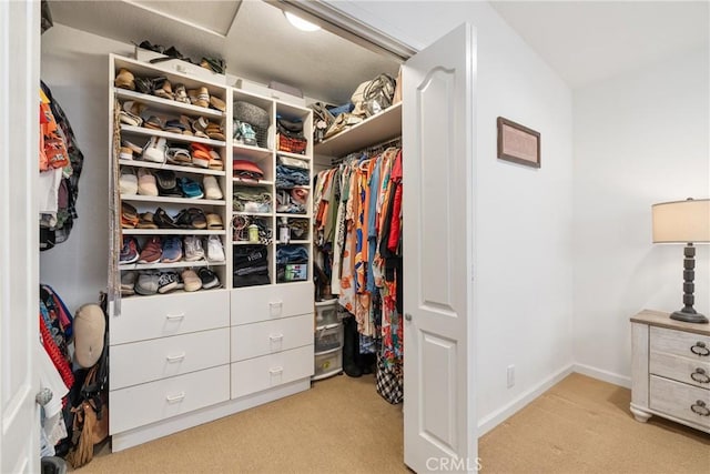 walk in closet with light colored carpet