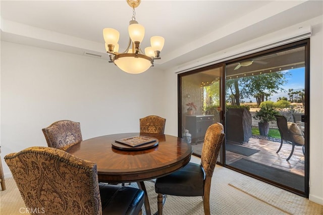 dining space featuring a chandelier, carpet flooring, and visible vents